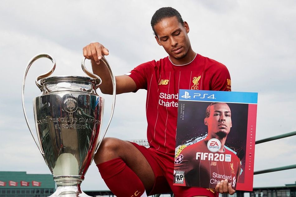 photo showing liverpool fc player virgil van dijk with champions league trophy and fifa cover