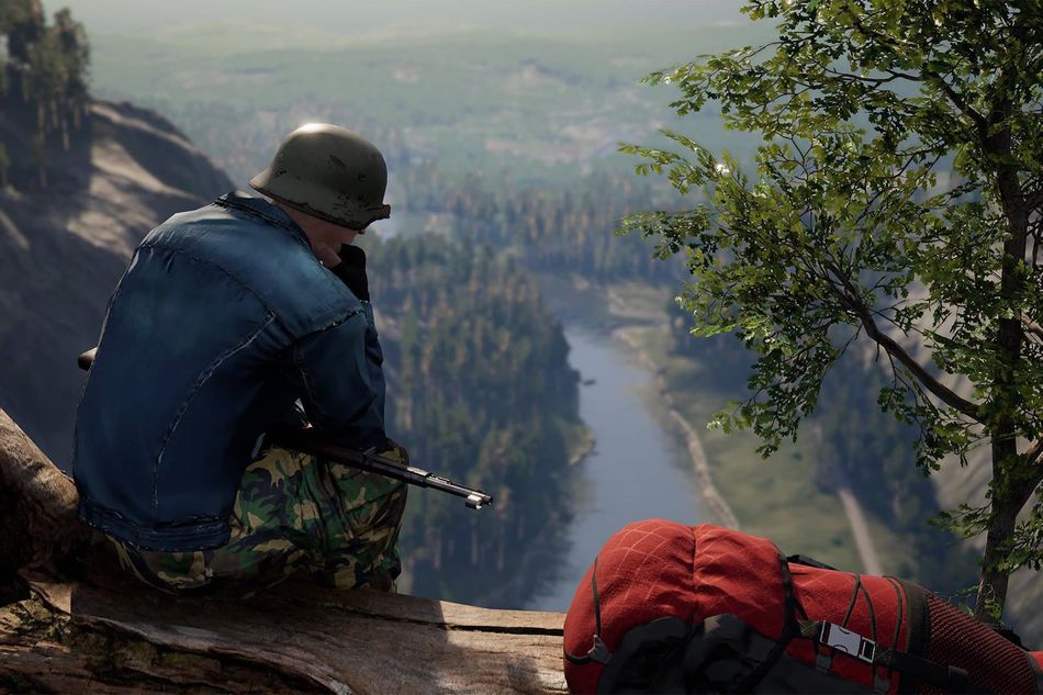 A man with a helmet and large backpack sitting on a log 