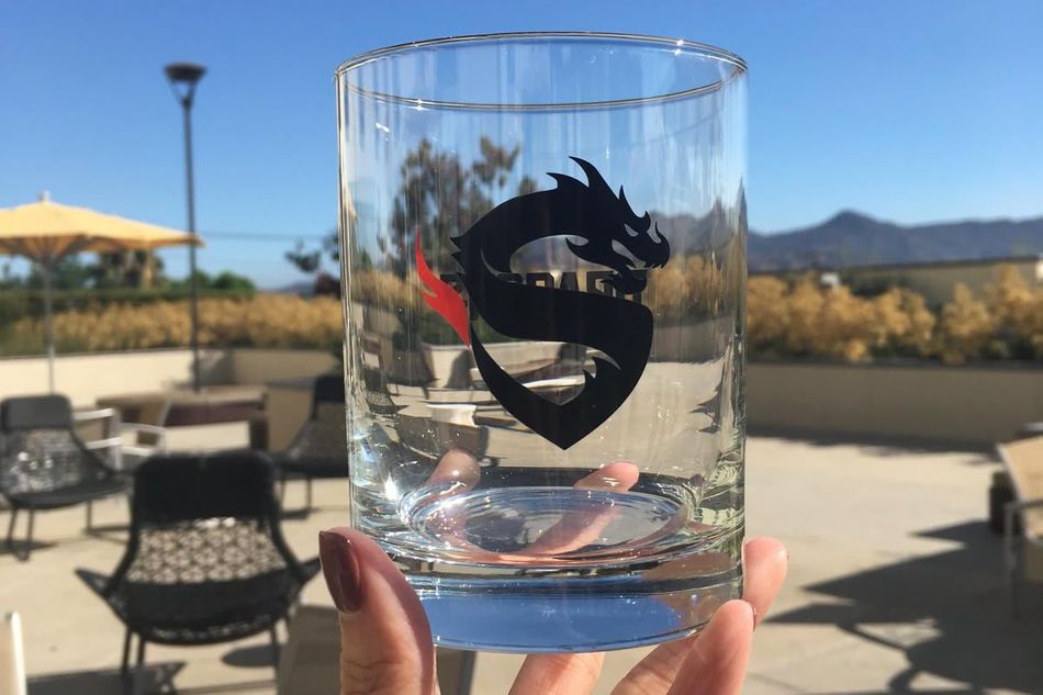 A glass with Shanghai Dragons logo on it