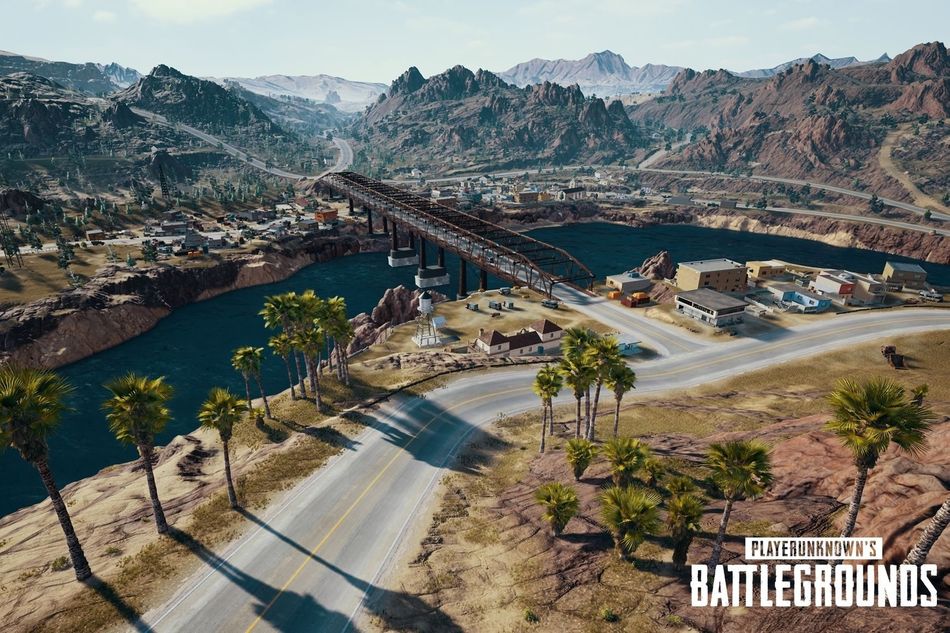 PlayerUnknown'sÂ Battlegrounds: aerial view of a map, with roads and a river. Mountains in the backdrop.