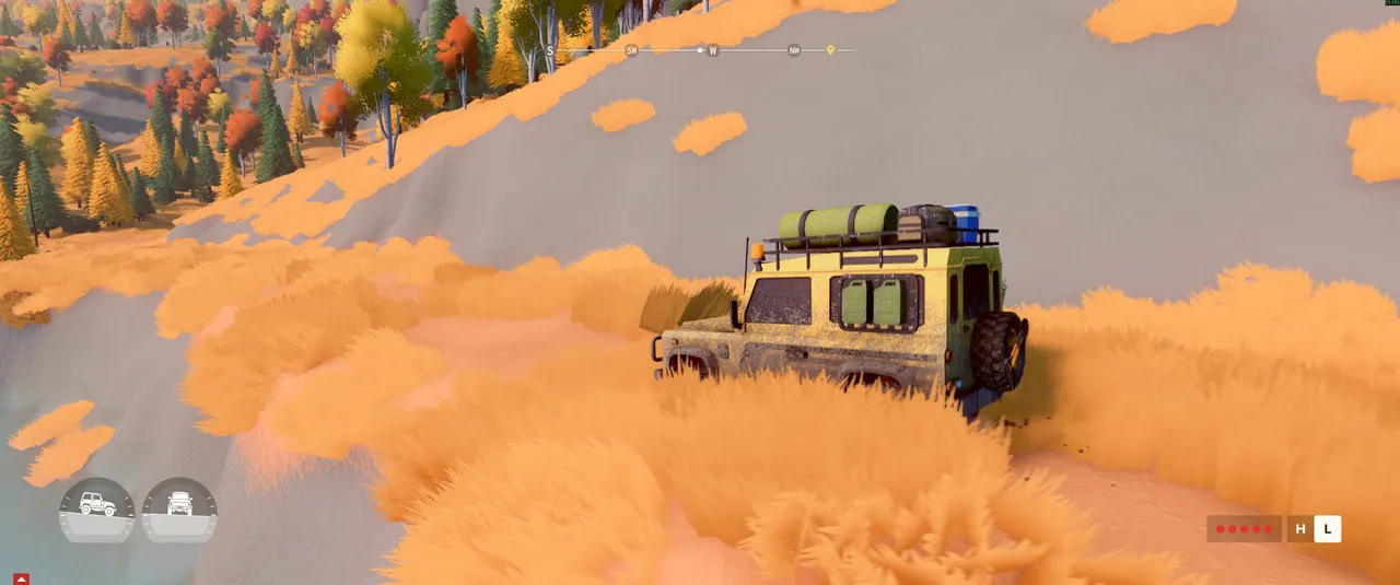 A kitted-out 4x4 pushes through thick golden grass on a steep slope, with the vehicle's tilt gauges in the bottom left showing just how precarious the angle is.